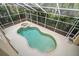 Aerial view of screened pool and spa surrounded by lush landscaping, creating a private oasis at 1370 Pinellas Rd, Belleair, FL 33756