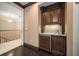 Elegant wet bar with dark wood cabinetry, granite countertop, and under-cabinet lighting at 1370 Pinellas Rd, Belleair, FL 33756