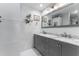 Bathroom with dual sink vanity, a large mirror, and decorative plants at 13815 Capitol Dr, Tampa, FL 33613