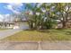 Charming single-story home with lush tropical landscaping in the front yard and an attached one-car garage at 13815 Capitol Dr, Tampa, FL 33613