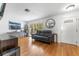 Inviting living room with wood floors, large windows, a leather couch and a decorative mirror at 13815 Capitol Dr, Tampa, FL 33613