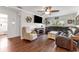 Living room featuring a beige armchair, a dark brown sectional sofa, and wood-look laminate flooring at 13815 Capitol Dr, Tampa, FL 33613