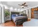 Relaxing main bedroom features a ceiling fan, wood floors, dresser, and ensuite bathroom with barn door at 13815 Capitol Dr, Tampa, FL 33613