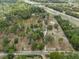 Aerial view of the expansive property showing the home, outbuildings, and surrounding trees at 14350 Hill Country Rd, Brooksville, FL 34614