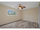 Bedroom with wood-look floors, ceiling fan, and natural light at 14350 Hill Country Rd, Brooksville, FL 34614