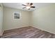 Bright bedroom featuring a ceiling fan, window, and wood-look floors at 14350 Hill Country Rd, Brooksville, FL 34614