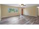 Sunlit living room with wood-look flooring, large window and ceiling fan at 14350 Hill Country Rd, Brooksville, FL 34614