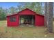 Large red outbuilding perfect for storage, with a tractor visible inside at 14350 Hill Country Rd, Brooksville, FL 34614