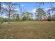 Expansive property with trees and red outbuilding offers ample space and serenity at 14350 Hill Country Rd, Brooksville, FL 34614