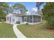 Exterior view of the house with screened in porch and well maintained yard at 14350 Hill Country Rd, Brooksville, FL 34614