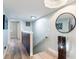 Hallway with wood floors, a staircase, decorative mirror, and modern lighting at 14700 Seminole Trl, Seminole, FL 33776