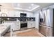 Bright kitchen featuring stainless steel appliances, white cabinets, a skylight, and a stylish countertop at 14700 Seminole Trl, Seminole, FL 33776