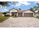 Charming home with three-car garage and decorative stone accents and brick paver driveway at 1604 Harvest Grove Ct, Valrico, FL 33596