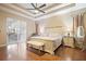 This is the home's primary bedroom featuring wood floors, a ceiling fan, and sliding glass door at 1604 Harvest Grove Ct, Valrico, FL 33596