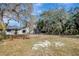 View of backyard with mature trees and a fire pit at 16106 Blackbeard Ln, Hudson, FL 34667