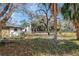 Spacious backyard featuring mature trees providing ample shade, enclosed by a chain-link fence for privacy at 16106 Blackbeard Ln, Hudson, FL 34667