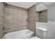 Updated bathroom showcasing tiled walls and a shower-tub combination at 16106 Blackbeard Ln, Hudson, FL 34667