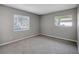 Neutral bedroom featuring carpeted floors and two windows allowing for natural light at 16106 Blackbeard Ln, Hudson, FL 34667