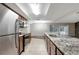 Open-concept kitchen featuring granite countertops, an island, and stainless steel appliances at 16106 Blackbeard Ln, Hudson, FL 34667