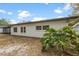 Exterior view of a house with a white wall, windows, an enclosed lanai, and a green plant at 1624 Barry Rd, Clearwater, FL 33756