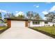 Charming single-story home featuring a well-manicured lawn and a white garage door at 1624 Barry Rd, Clearwater, FL 33756