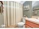 Neutral bathroom featuring a toilet, shower with striped curtain, and seaside decor at 19131 Weymouth Dr, Land O Lakes, FL 34638