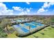 Aerial view of community tennis courts, surrounded by lush greenery and palm trees at 19131 Weymouth Dr, Land O Lakes, FL 34638