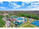 Aerial view of a community pool, tennis courts, and nearby amenities at 19131 Weymouth Dr, Land O Lakes, FL 34638