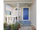 Cozy front porch with a blue door, decorative columns, and potted plants, creating a welcoming entrance at 19131 Weymouth Dr, Land O Lakes, FL 34638