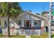 Charming home with a red door, white picket fence, landscaped yard, and freshly painted exterior at 2024 E Columbus Dr, Tampa, FL 33605