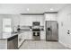 Bright kitchen with stainless steel appliances, white cabinetry, and granite countertops at 2024 E Columbus Dr, Tampa, FL 33605