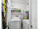 Efficient laundry room featuring a washer, dryer, and shelving for storage at 2024 E Columbus Dr, Tampa, FL 33605