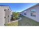 View of the backyard featuring the house, shed, grass, garden with stone path, and partial fencing at 2112 Purple Orchid Pl, Ruskin, FL 33570