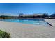 Community pool with shade coverings surrounded by a paved pool deck and a black metal fence at 2112 Purple Orchid Pl, Ruskin, FL 33570