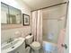 Clean bathroom with a sink, toilet, and bathtub with a floral shower curtain at 2434 Australia E Way # 44, Clearwater, FL 33763