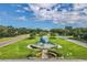 Scenic community entrance featuring a globe water feature surrounded by lush landscaping at 2434 Australia E Way # 44, Clearwater, FL 33763