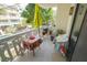 Cozy condo balcony featuring a colorful table setting and a partial view of surrounding trees and buildings at 2612 Pearce Dr # 210, Clearwater, FL 33764