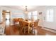 Cozy dining room with wood table, six chairs, stylish lighting, and an open entryway at 36806 Niles Dr, Zephyrhills, FL 33542