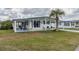 Well-maintained home featuring a covered carport, cozy front porch, and a lush green lawn at 36806 Niles Dr, Zephyrhills, FL 33542