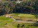 Scenic aerial view of the community golf course, with golf carts driving by, surrounded by lush landscaping at 36806 Niles Dr, Zephyrhills, FL 33542