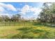 Expansive backyard with a black fence and scenic views of trees and sky, offering privacy and tranquility at 38205 Countryside Pl, Dade City, FL 33525