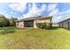 Well-maintained backyard with lush green grass, a black iron fence, and solar panels on the roof at 38205 Countryside Pl, Dade City, FL 33525