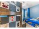 Bright bedroom featuring blue walls and a playful race car bed, with a creative animal-themed quilt on the bunk bed at 38205 Countryside Pl, Dade City, FL 33525