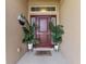 Inviting front entry with a maroon door, complete with potted palms for a warm and welcoming curb appeal at 38205 Countryside Pl, Dade City, FL 33525