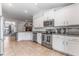 Well-lit kitchen featuring stainless appliances, generous cabinetry, and durable tiled flooring at 38205 Countryside Pl, Dade City, FL 33525