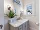 Stylish bathroom featuring a gray vanity, beautiful mirror, and stylish lighting at 610 Casabella Dr, Bradenton, FL 34209