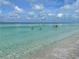 Stunning view of people swimming in clear, turquoise waters at the beach at 610 Casabella Dr, Bradenton, FL 34209