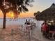 Sunset view of a beach bar with patrons enjoying the evening and a lifeguard tower at 610 Casabella Dr, Bradenton, FL 34209