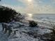 Tranquil beach scene featuring a bench with a view of the ocean and setting sun at 610 Casabella Dr, Bradenton, FL 34209