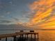 Scenic view of dock at sunset with warm orange glow on the water at 610 Casabella Dr, Bradenton, FL 34209